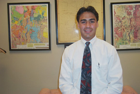 Justin Mirabal standing in front of maps in Senator Bingaman's office