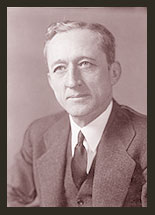 A black and white photo of Senator Carl A. Hatch, who is wearing a dark tie, dark jacket, and whit shirt.