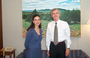 Amanda Casarez-Smith standing alongside Senator Bingaman in front of a landscape mural