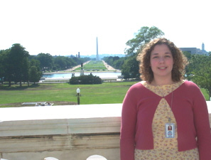 Photo of intern Jenny McKay, who is standing before a marble ledge. Over her left shoulder is the National Mall and the Washington Monument.