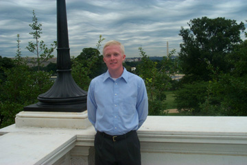 David Roach standing on the outside of the Capitol next to a lamp post