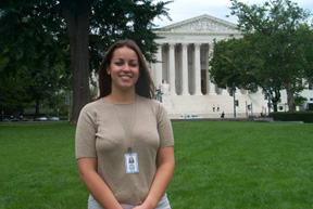 Elizabeth Louton standing on a grass lawn in front of the Supreme Court