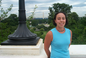 Nicole Chavez perched next to a capitol lamp post, the Washington Monument in the background