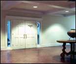 Photo of the inside of 119 East March, a dynamically lit foyer with a large wooden table and Native American pot in the foreground.