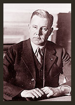 A black and white photo of Senator Bronson M. Cutting, who is wearing a dark suit, a white shirt, and dark tie.